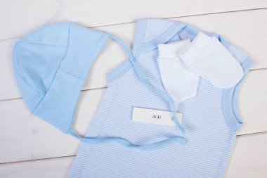 Hamilelik testi pozitif sonuç ve giyim için yeni doğan bebek için bekliyor,