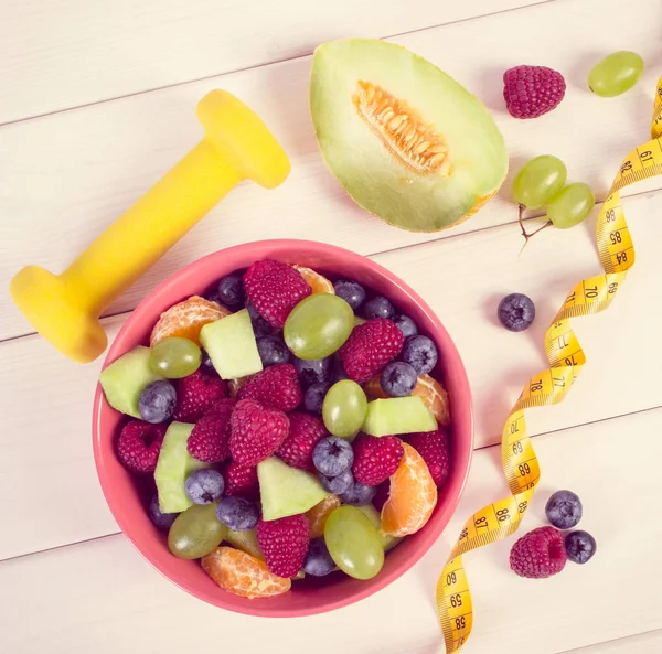 Foto vintage, Salada de frutas frescas e centímetro com halteres, estilo de vida saudável e conceito de nutrição — Fotografia de Stock