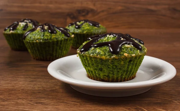 Muffins frescos com espinafre, coco desidratado e cobertura de chocolate, deliciosa sobremesa saudável — Fotografia de Stock