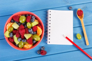 Taze meyve salatası ve notlar, sağlıklı yaşam ve beslenme kavramı yazmak için not defteri