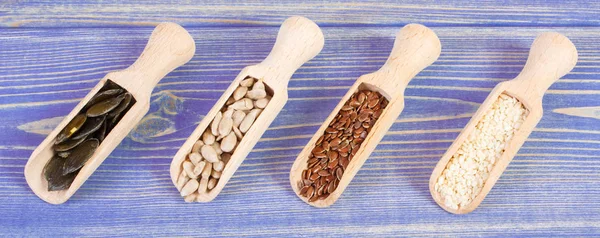 Semi di lino, girasole, zucca e semi di sesamo su tavole di legno, concetto di alimentazione sana — Foto Stock