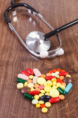 Kalp renkli tıbbi hap ve kapsül şeklinde stetoskop ile sağlık kavramı