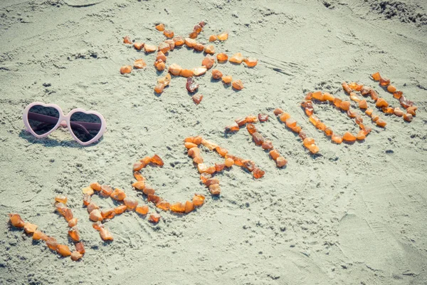 Vintage photo, Word vacation with shape of sun and sunglasses on sand at beach, summer time — Stock Photo, Image