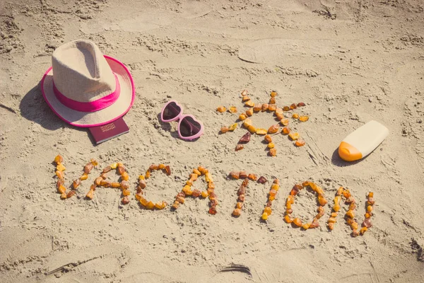 Foto vintage, Vacaciones de la palabra, accesorios para tomar el sol y pasaporte en la arena en la playa, hora de verano — Foto de Stock