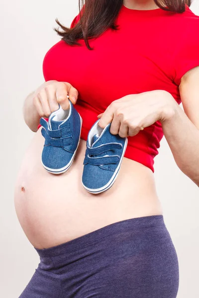 Zwangere vrouw met baby schoenen, verwacht voor baby — Stockfoto