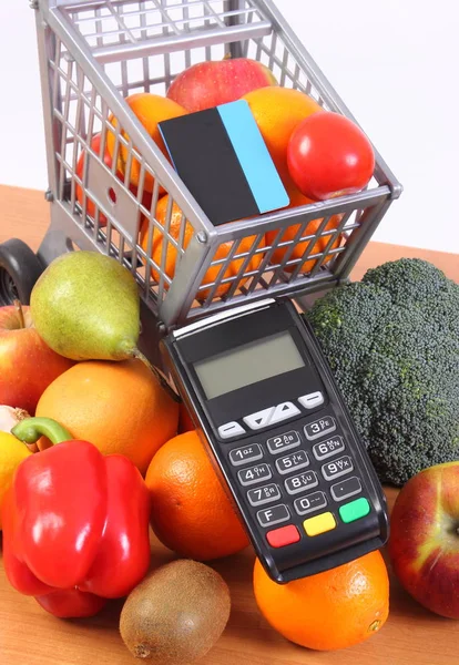 Платежный терминал с бесконтактной кредитной картой, фруктами и овощами, безналичная оплата покупок — стоковое фото