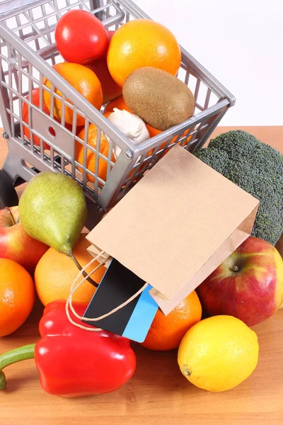 Бесконтактная кредитная карта, бумажный пакет и фрукты с овощами, безналичная оплата покупок — стоковое фото