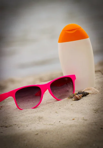 贝壳、 粉色墨镜和防晒霜上海滩上的沙子 — 图库照片