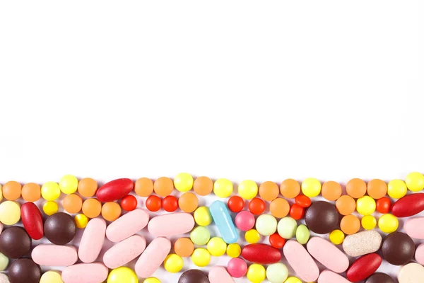 Coloridas píldoras y cápsulas médicas sobre fondo blanco, concepto de atención médica, espacio de copia para texto — Foto de Stock