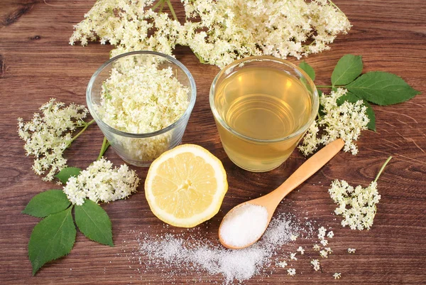 Blüten und Holundersaft, Zutaten für die Zubereitung von Getränken auf rustikalem Brett — Stockfoto