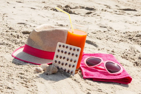 Medyczne pigułki, sok z marchwi i akcesoria do opalania na plaży, witaminy A i piękny, trwały tan — Zdjęcie stockowe