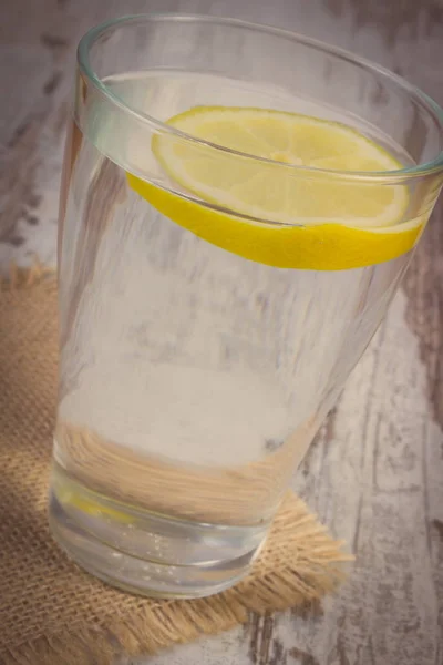 Винтажное фото, стакан чистой воды с ломтиком лимона, холодный лимонад — стоковое фото