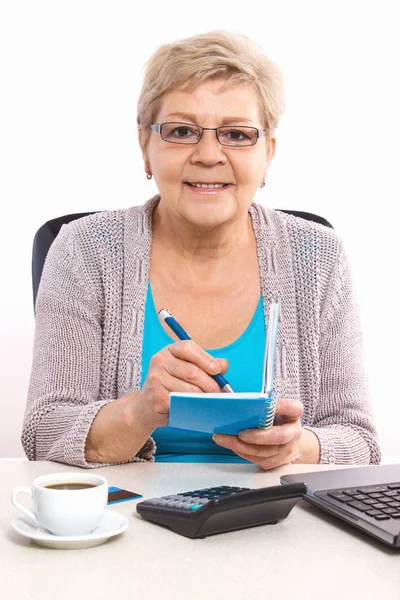 Oudere senior vrouw schrijven in laptop of kalender — Stockfoto