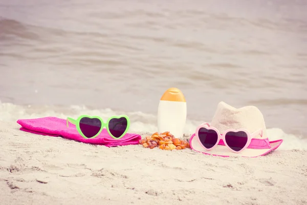 Pierres ambrées et accessoires pour des vacances sur le sable à la plage, protection solaire, heure d "été — Photo