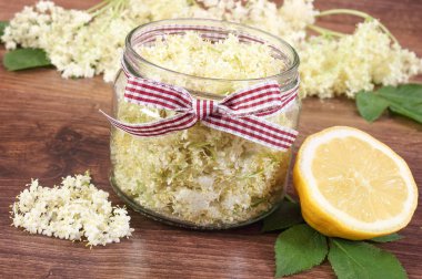 Mürver çiçekleri ve limon rustik tahta üzerinde taze sağlıklı meyve suyu hazırlama