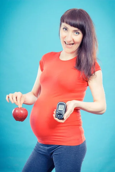 Donna incinta felice con mela e glucometro con un buon livello di zucchero risultato, diabete e nutrizione durante la gravidanza — Foto Stock