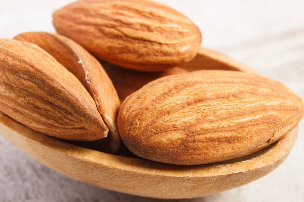 Closeup of almonds on wooden spoon — Stock Photo, Image