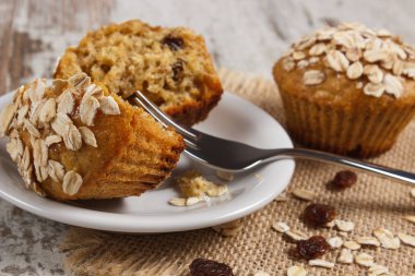 Kepekli un beyaz tabakta, lezzetli sağlıklı tatlı taze çörek yulaf ezmesi ile pişmiş