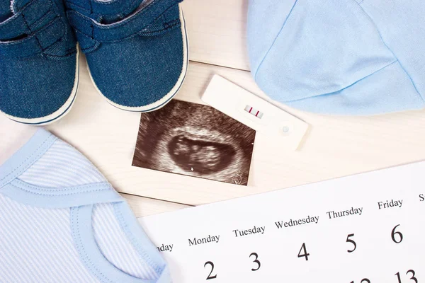 Test di gravidanza, ecografia del bambino, abbigliamento per neonato e calendario, attesa per il bambino — Foto Stock