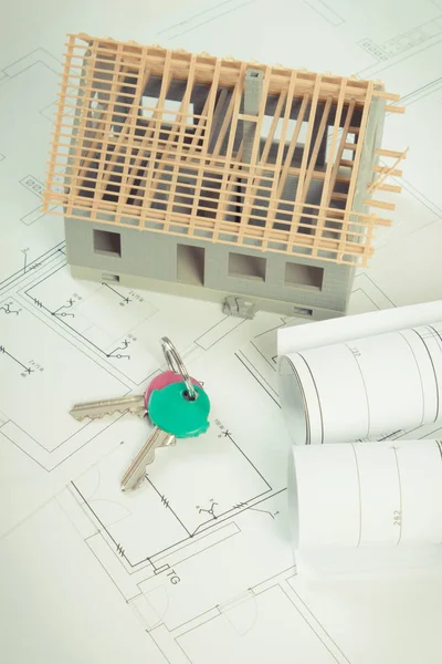 Electrical drawings, home keys and small house under construction, concept of building home