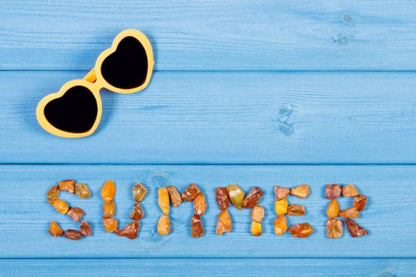 Wort Sommer aus Bernstein und Sonnenbrille, Konzept der Sommerzeit, Kopierraum für Text — Stockfoto