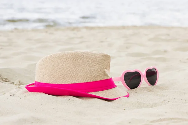 Sunglasses and straw hat at beach, sun protection and summer time concept — Stock Photo, Image