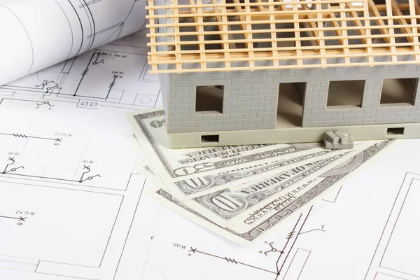 Casa en construcción y monedas dólar en dibujos eléctricos y diagramas para el proyecto, la construcción de concepto de costo de la vivienda — Foto de Stock