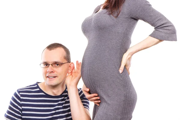 Щасливий батько слухає живіт своєї дружини, очікуючи новонародженого — стокове фото