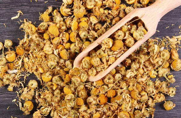 Heap of dried chamomile on wooden board, alternative medicine — Stock Photo, Image