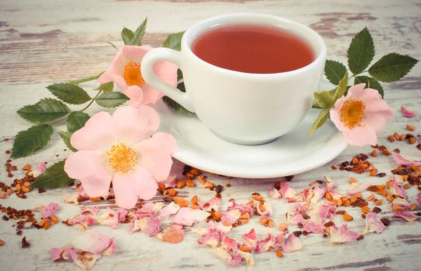 老式的照片，杯茶，野生玫瑰花卉旧仿古板上 — 图库照片