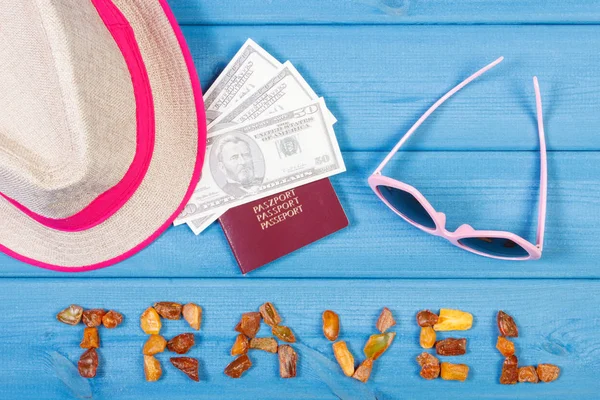 Viaje de palabra, gafas de sol, sombrero de paja, pasaporte y monedas dólar, verano o concepto de tiempo de vacaciones — Foto de Stock