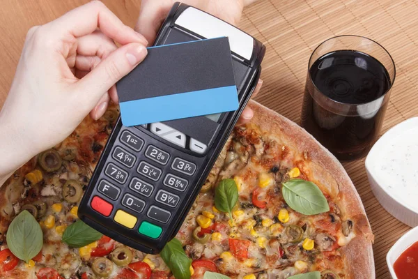Использование платежного терминала с бесконтактной кредитной картой для оплаты в ресторане — стоковое фото