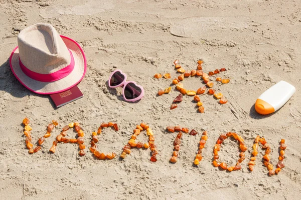 Palabra de vacaciones, accesorios para tomar el sol y pasaporte en la playa, concepto de hora de verano — Foto de Stock