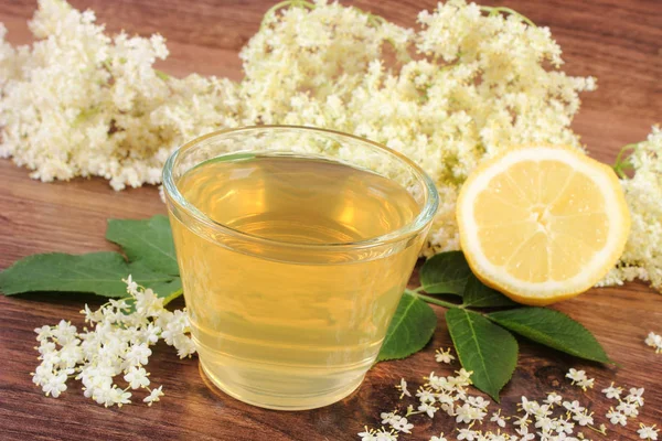 Zumo fresco y saludable, flores de saúco y limón a bordo, concepto de medicina alternativa — Foto de Stock