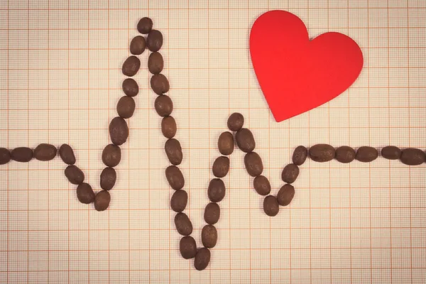 Cardiograma linha de grãos de café torrados e coração vermelho, conceito de medicina e cuidados de saúde — Fotografia de Stock