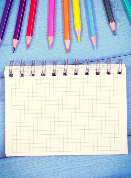 Красочные карандаши и блокнот на досках, школьные принадлежности, пространство для копирования текста — стоковое фото