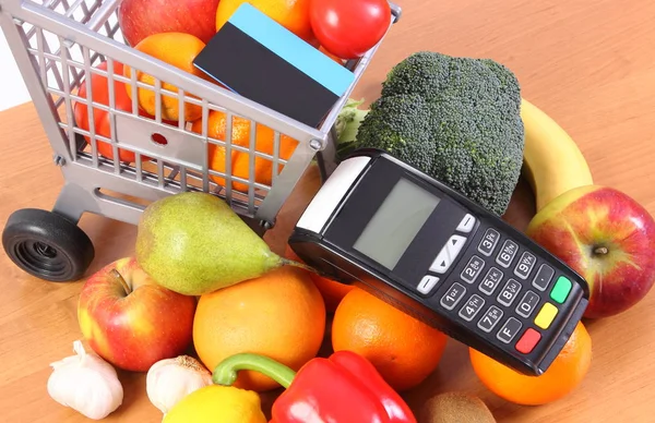 Платежный терминал с бесконтактной кредитной картой, фруктами и овощами, концепция безналичной оплаты покупок — стоковое фото