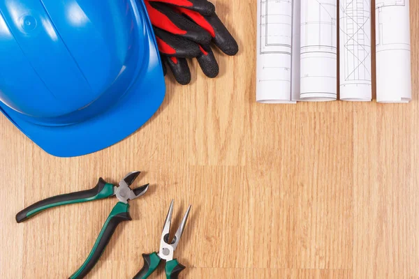 Rolos de desenhos ou modelos eléctricos, capacete de protecção com luvas e ferramentas de trabalho, acessórios para trabalhos de engenharia — Fotografia de Stock