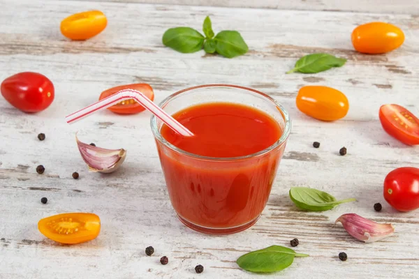 Tomatensap en fruit met specerijen op oude rustieke bord — Stockfoto