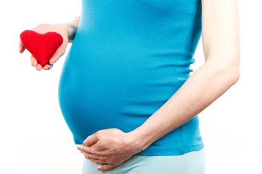 Kırmızı kalp, yeni bir hayat sembolü tutarak ve yenidoğan için bekliyor hamile kadın