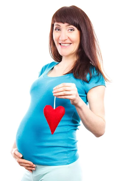 Gelukkig lachende zwangere vrouw met rood hart, symbool van nieuw leven en verwacht voor pasgeboren — Stockfoto