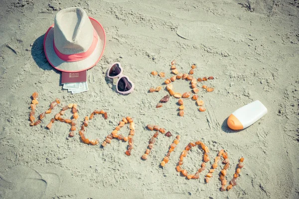 Palavra férias, acessórios para banhos de sol e passaporte com moedas dólar na praia, viajar no conceito de verão — Fotografia de Stock