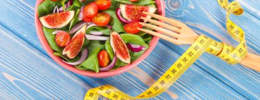 Meyve ve sebze salatası ve çatal mezura mavi panoları, sağlıklı beslenme kavramı ile