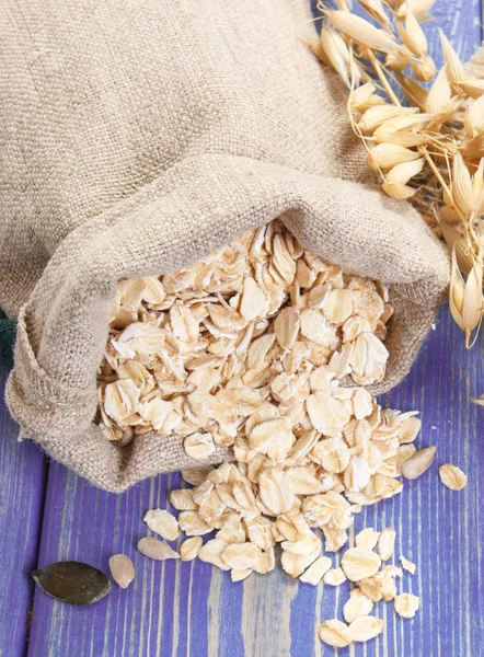 Oat flakes in jute bag, healthy ingredients for baking oatmeal cookies