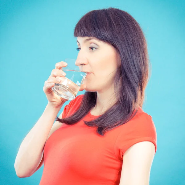 Jahrgangsfoto, lächelnde Frau, die Mineralwasser aus Glas trinkt, Konzept des Lebensstils und der Hydratation — Stockfoto