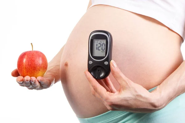 Terhes nő vércukormérő és a friss alma, koncepció, az egészséges táplálkozás a terhesség alatt — Stock Fotó