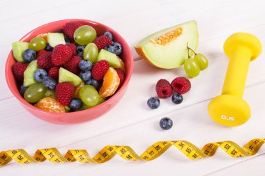 Meyve salatası ve santimetre dambıl, sağlıklı yaşam, gıda ve beslenme