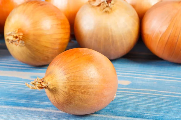 Haufen frischer Zwiebeln auf Brettern liegend, gesundes Ernährungskonzept — Stockfoto