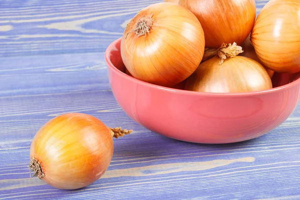 Zwiebelhaufen in Schüssel auf Brettern, gesunde Ernährung — Stockfoto