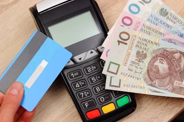 Деньги в польской валюте и кредитная карта с терминалом оплаты — стоковое фото